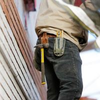 Construction worker standing on ladder.